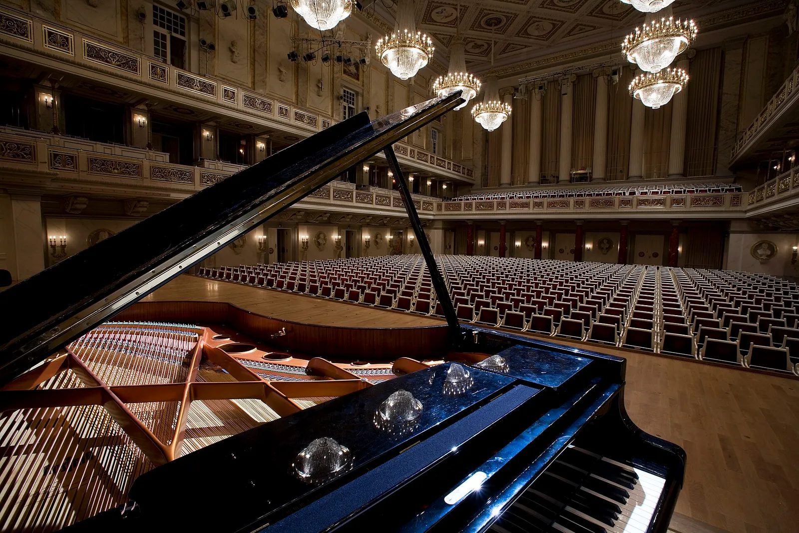 Un pianoforte a coda sul palco di una sala da concerto